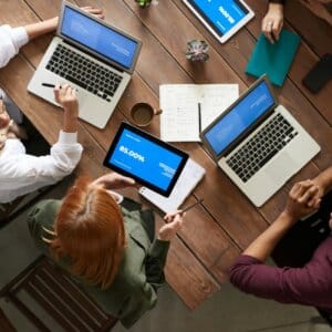 top view photo of group of people using macbook while discussing