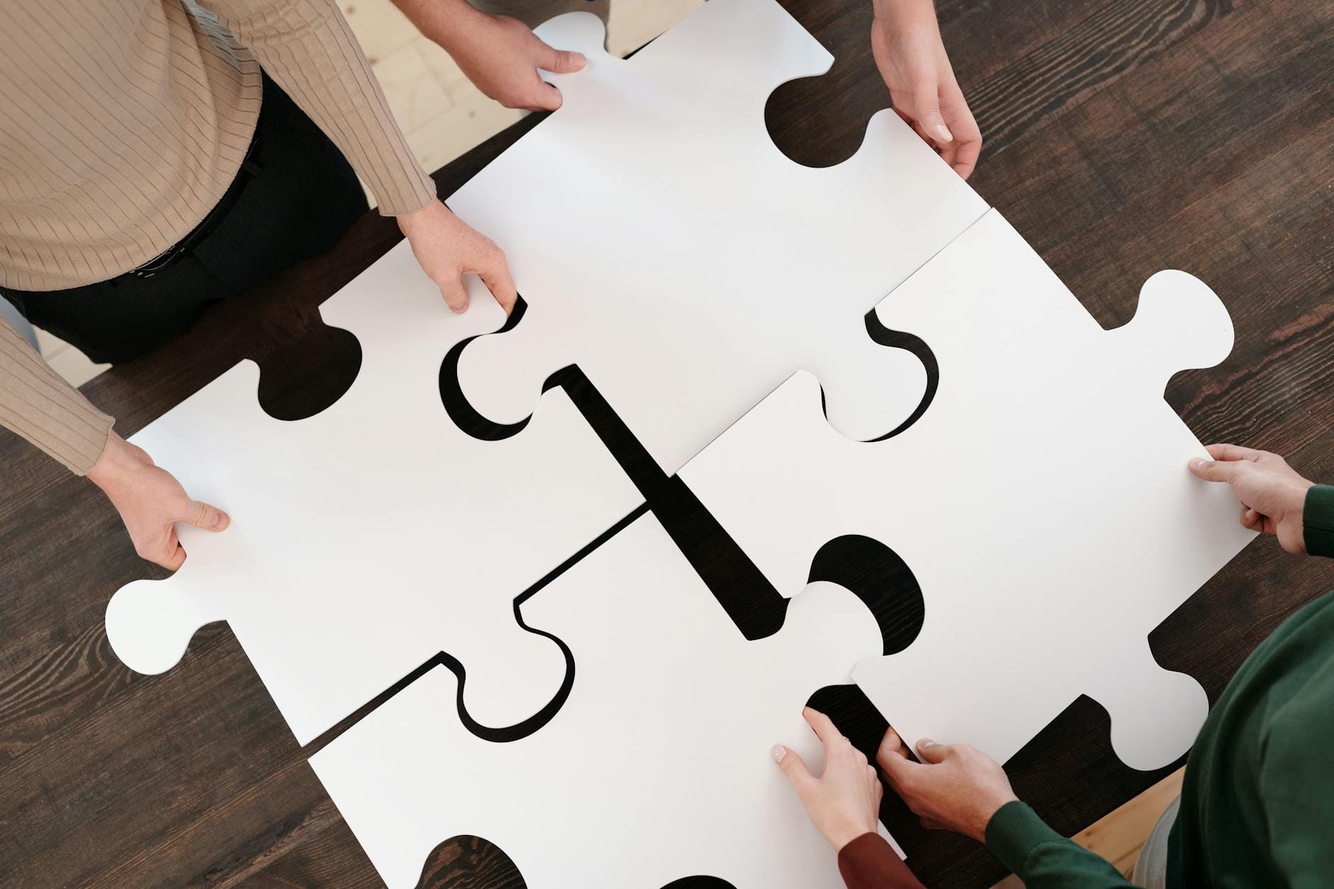Group of people connecting puzzle pieces, representing how SEO, Meta Ads, and Google Ads should work together rather than separately
