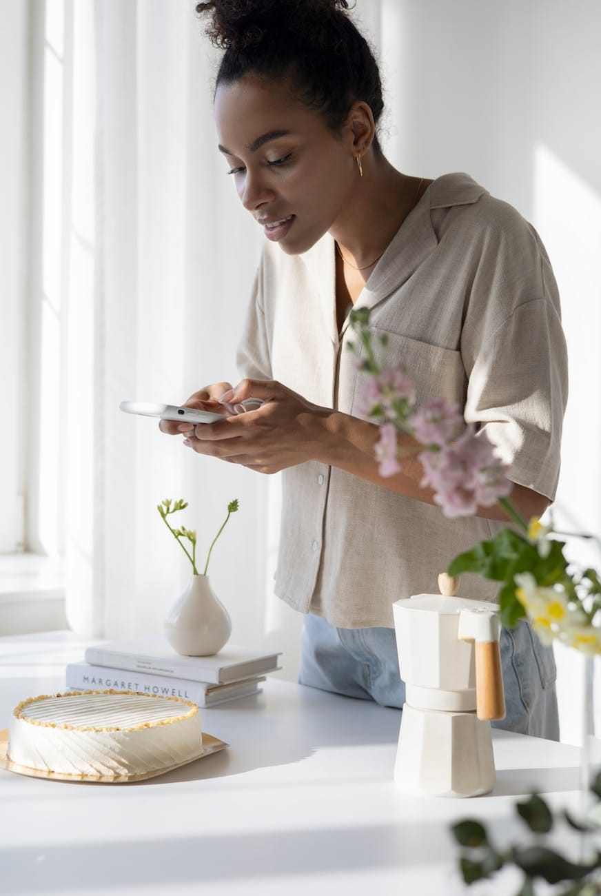 woman in white dress shirt holding white smartphone