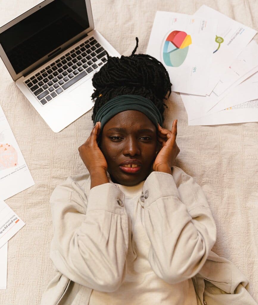 woman in pain lying near a laptop