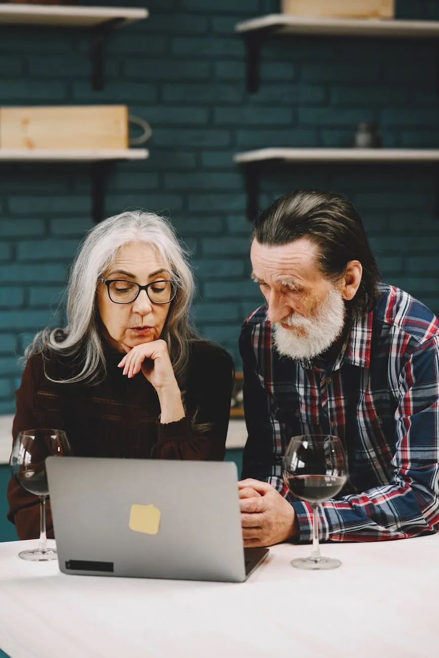 elderly couple looking at a gray laptop