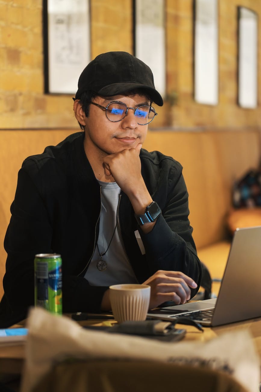 young man working at cafe with laptop and coffee