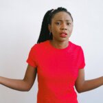 girl in red crew neck shirt looking confused