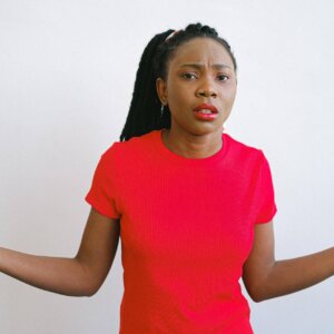 girl in red crew neck shirt looking confused